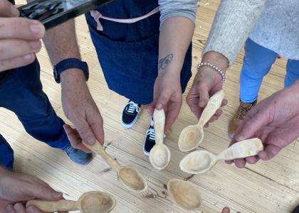 Group of hands showing off the spoons they made in class. 