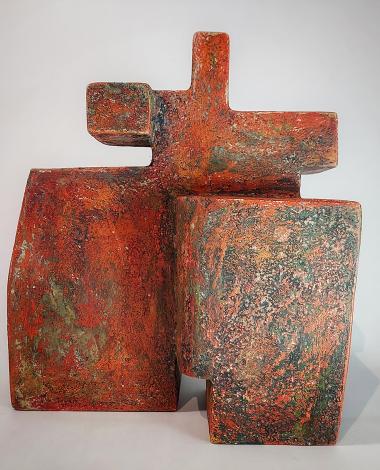 photo of cubist stone sculpture in orange and green, grey background